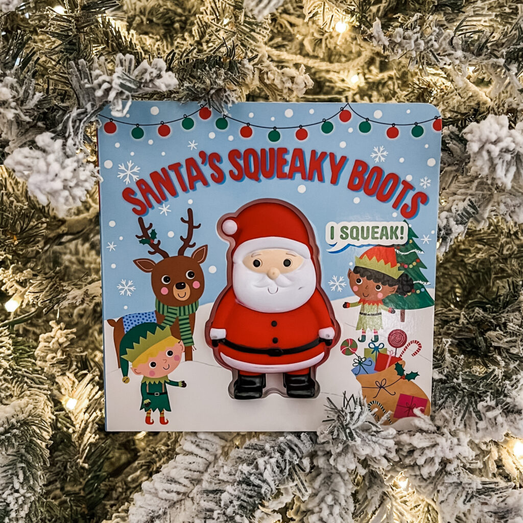 Santa's Squeaky Boots board book on a Christmas tree background