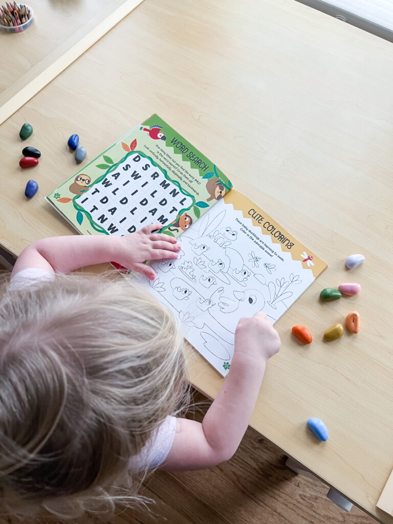 Child completing activity from children's book Super Puffy Stickers! Baby Animals